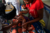 Toddler being held by his or her mother while getting injected with a shot by a nurse in an African clinic.