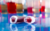 Two capped vials of blood placed on their sides, on a table, in a lab.